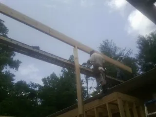 Carpenter setting a ridge beam over a new addition frame — Ice Dam Removal by Roofing Brothers in Tonganoxie