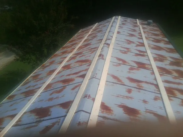 Rusted metal roof panels with new wood purlins before replacement — Storm Damage Roof Repair in Tonganoxie by Roofing Brothers