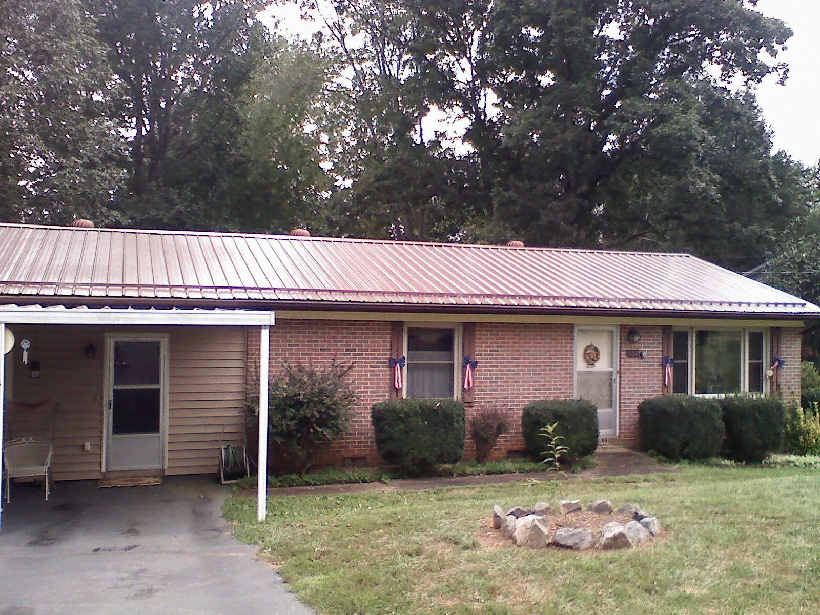Bronze metal roof and carport on a brick ranch home — Roof Repair work by our crew in Tonganoxie